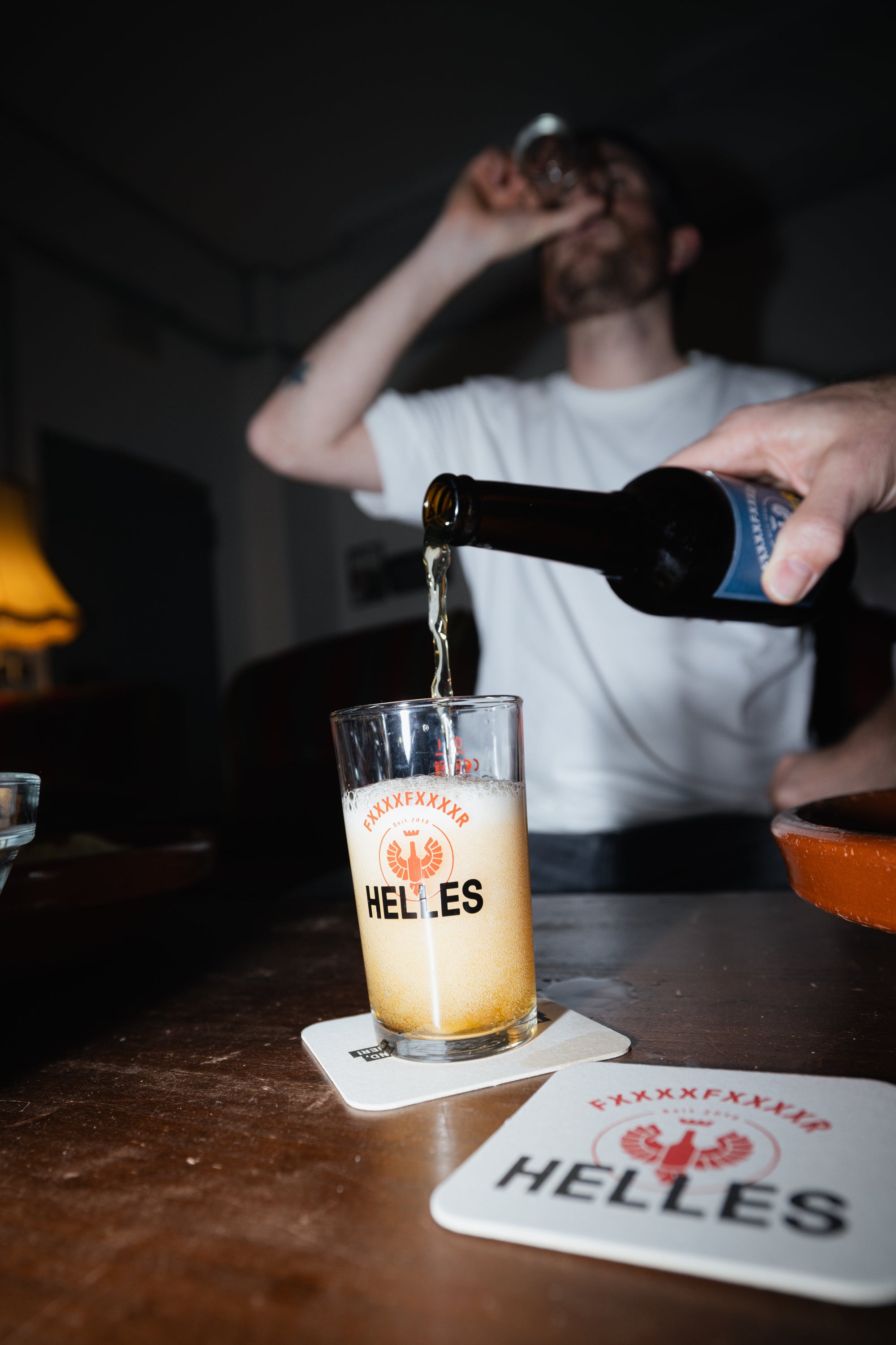 Eine Person gießt Bier in ein Glas ein.